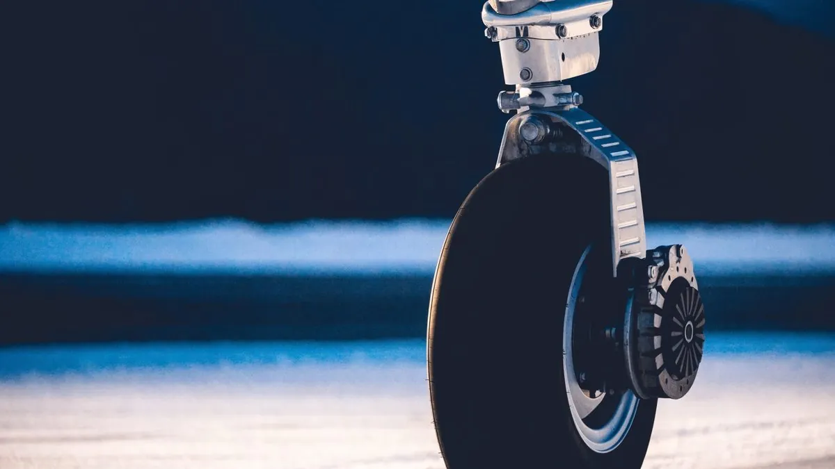 Close-up of a private jet's nose landing gear on a snowy ramp